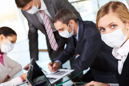 Serious businesswoman in mask working in the office