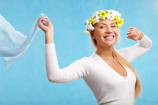 Portrait of blond smiling female with floral wreath holding shawl