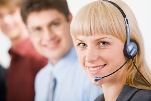 Portrait of friendly smiling telephone operator on the background of colleagues