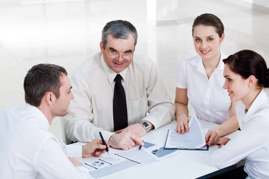 Photo of confident co-workers planning new project at briefing