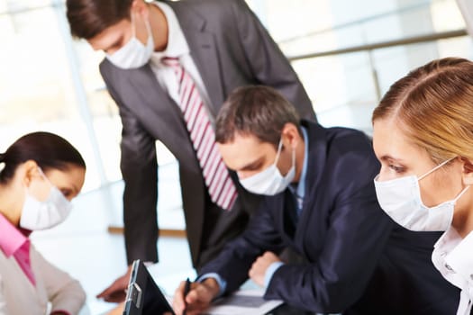 Serious businesswoman in mask in working environment