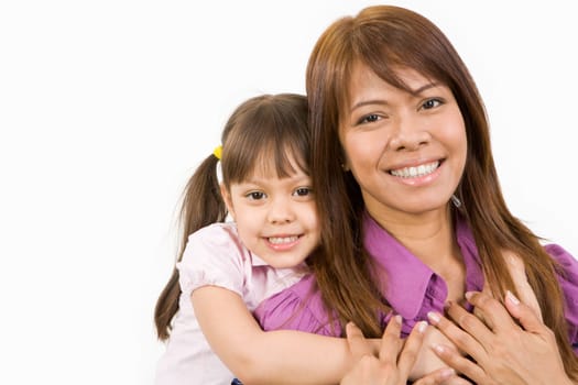 Happy child embracing her loving mother and both looking at camera