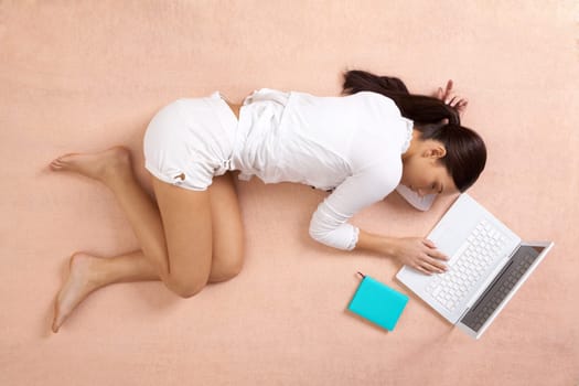 View from above of peaceful girl having a nap with laptop near by
