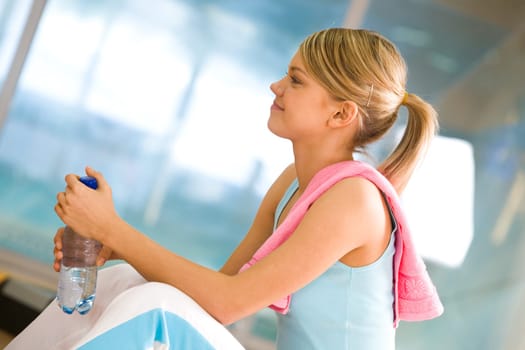 Image of smiling girl with bottle in hand looking straight