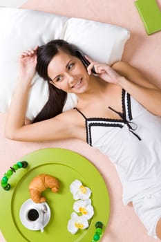 View from above of friendly girl speaking on cellular phone with her friend