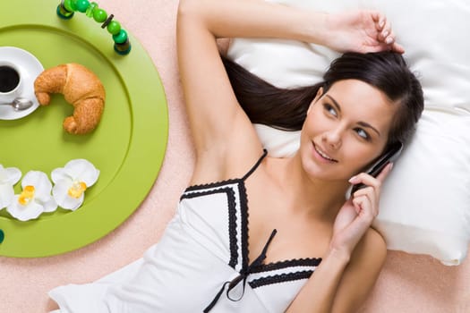 Close-up of smiling girl talking on cellular phone with her friend