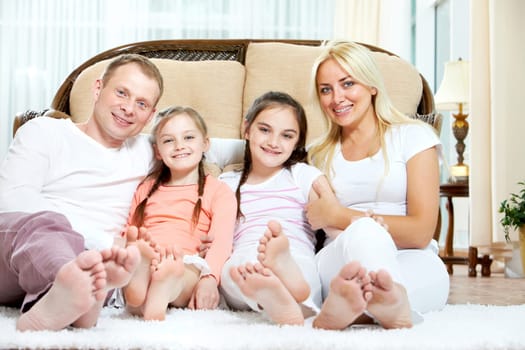 Portrait of happy family with two children sitting at home