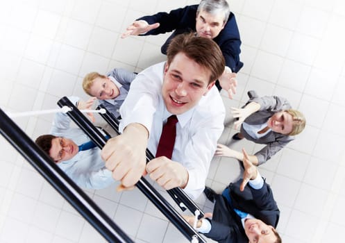 Above view of businessman ascending the ladder with his crew beneath