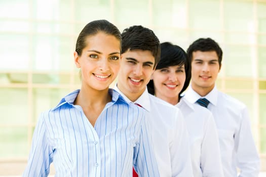 Portrait of attractive leader of friendly business group standing in line behind