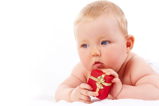 Portrait of pretty baby with red giftbox looking aside
