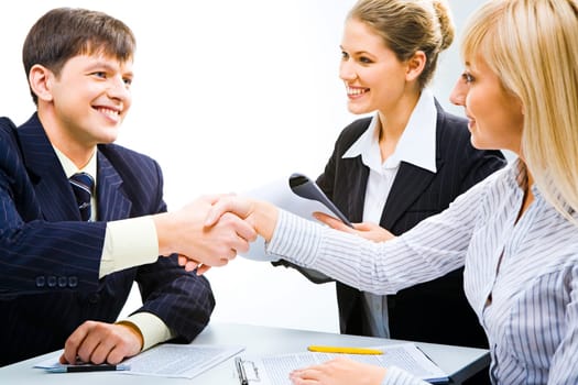 Business partners shaking hands and looking at each other at meeting