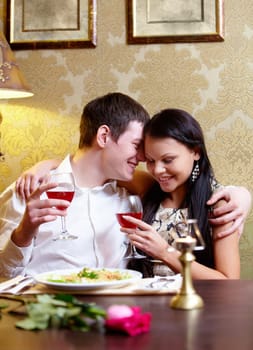 Portrait of pair of lovers holding glasses during lunch