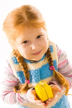 Above view of cute girl with small gift in hands looking slightly upwards