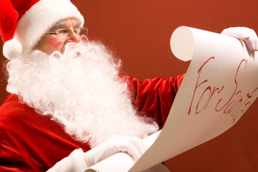 Portrait of Santa Claus reading big letter attentively