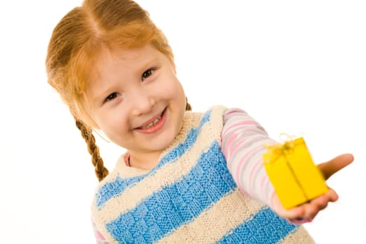 Little redheaded girl giving somebody small present in yellow box and smiling