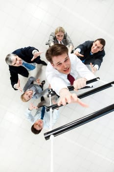 Above view of businessman ascending the ladder with his crew beneath