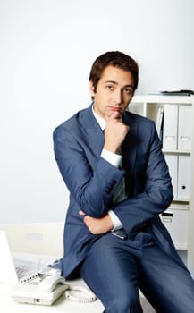 Portrait of pensive businessman in suit thinking in office