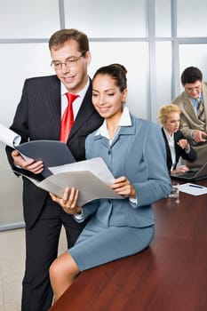 Two business people are looking in the documents