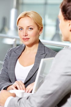 Portrait of pretty woman at workplace looking at camera