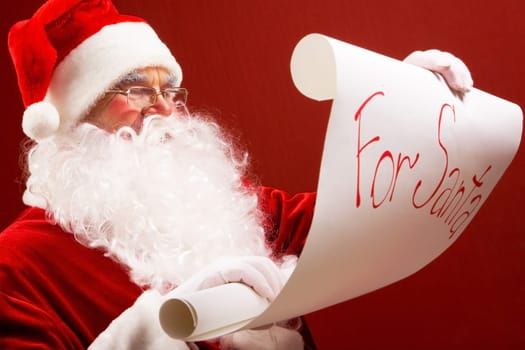 Portrait of Santa Claus reading big letter attentively
