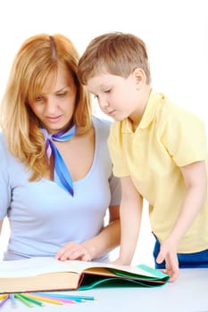Photo of cute preschooler and his mother looking into book