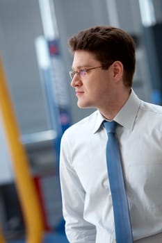 Portrait of confident businessman looking aside through eyeglasses