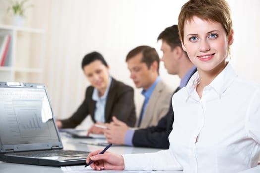 Image of pretty blue-eyed female looking at camera in working environment
