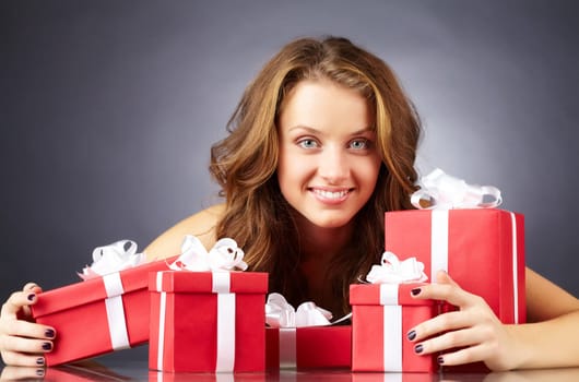 Portrait of a girl with giftboxes looking at camera and smiling