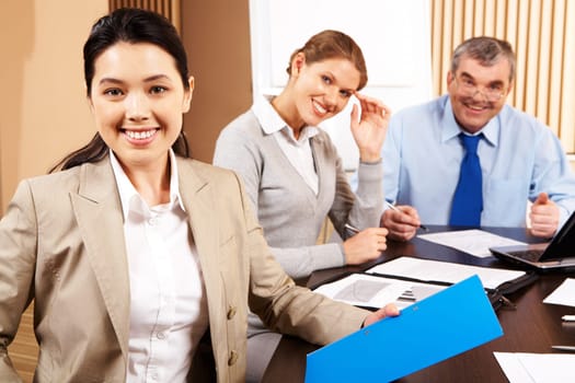 Image of attractive female on background of smart co-workers