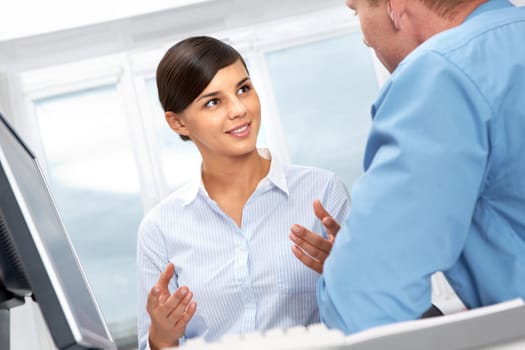 Young office worker asking her colleague