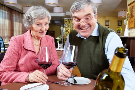 Image of couple looking at good wine while sitting at a restaurant