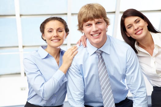 Portrait of friendly three business people looking at camera