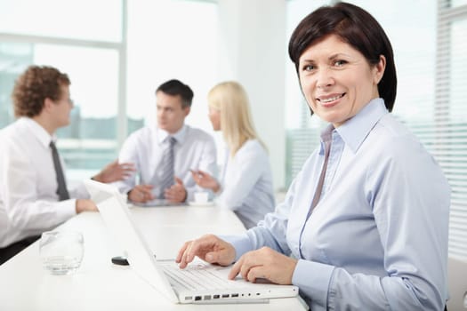 Mature businesswoman at workplace looking at camera in working environment