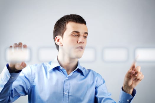 Image of businessman holding and pressing virtual button