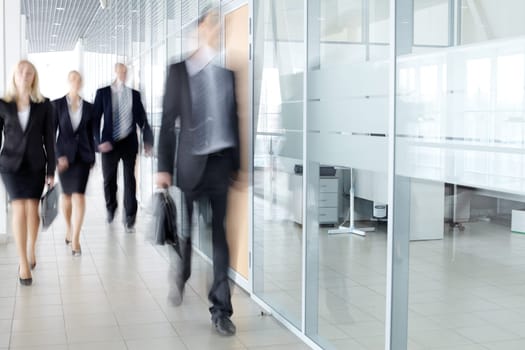 Several businesspeople walking in the corridor