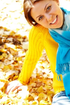 Portrait of joyful woman sitting on foliage
