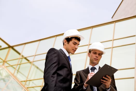 Photo of serious employees looking at document while planning work