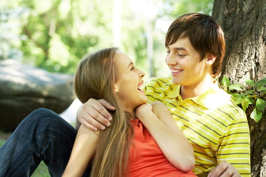 Image of happy couple laughing while having rest outside