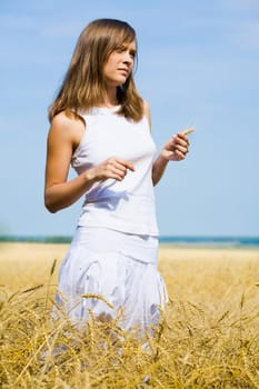Portrait of pretty girl in white clothes holding ear