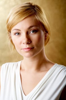Portrait of elegant woman looking with smile over golden background