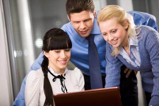Group of confident employees looking at monitor while planning work