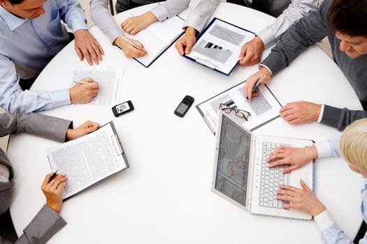 Image of company of successful partners discussing business plan at meeting