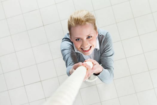 Image of businesswoman ascending up the rope with big efforts