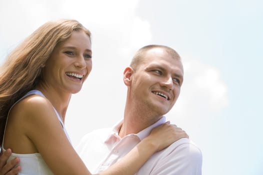 Portrait of happy couple laughing over blue background