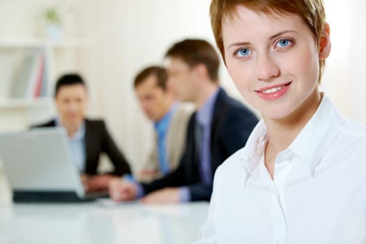Image of pretty blue-eyed female looking at camera in working environment