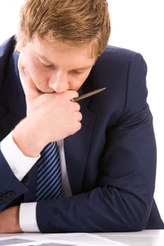 Portrait of thoughtful businessman looking at documents while planning work