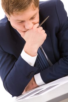 Portrait of thoughtful businessman looking at documents while planning work