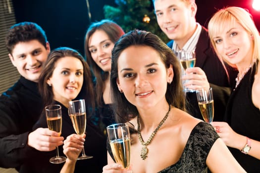 Beautiful woman raising up her glass on the background of five friends