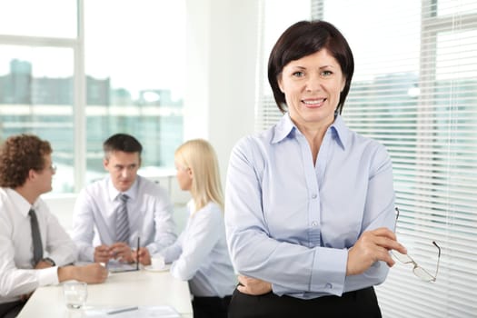 Mature businesswoman looking at camera in working environment