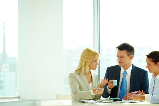 Smart woman explaining her idea to colleagues in office